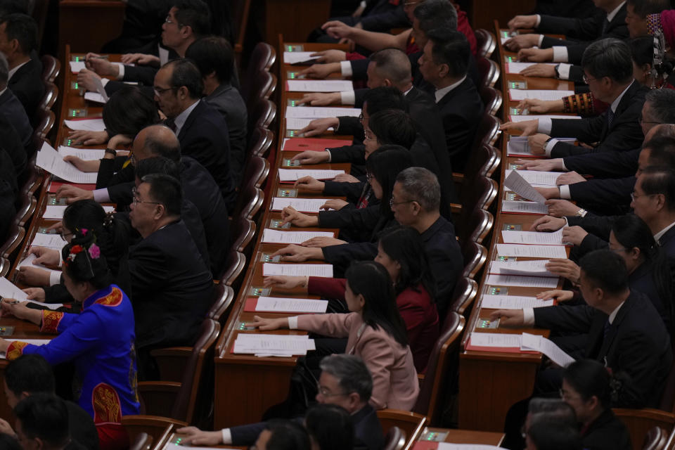 Delegates press buttons to vote during the closing session of the National People's Congress (NPC) at the Great Hall of the People in Beijing, Monday, March 11, 2024. (AP Photo/Andy Wong)