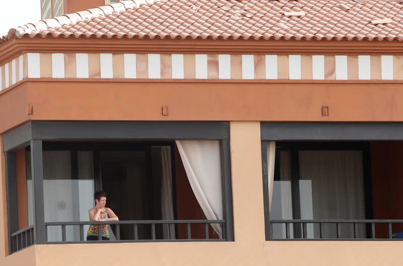 A woman looks from a terrace of H10 Hotel, which is on lockdown after novel coronavirus has been confirmed in Adeje