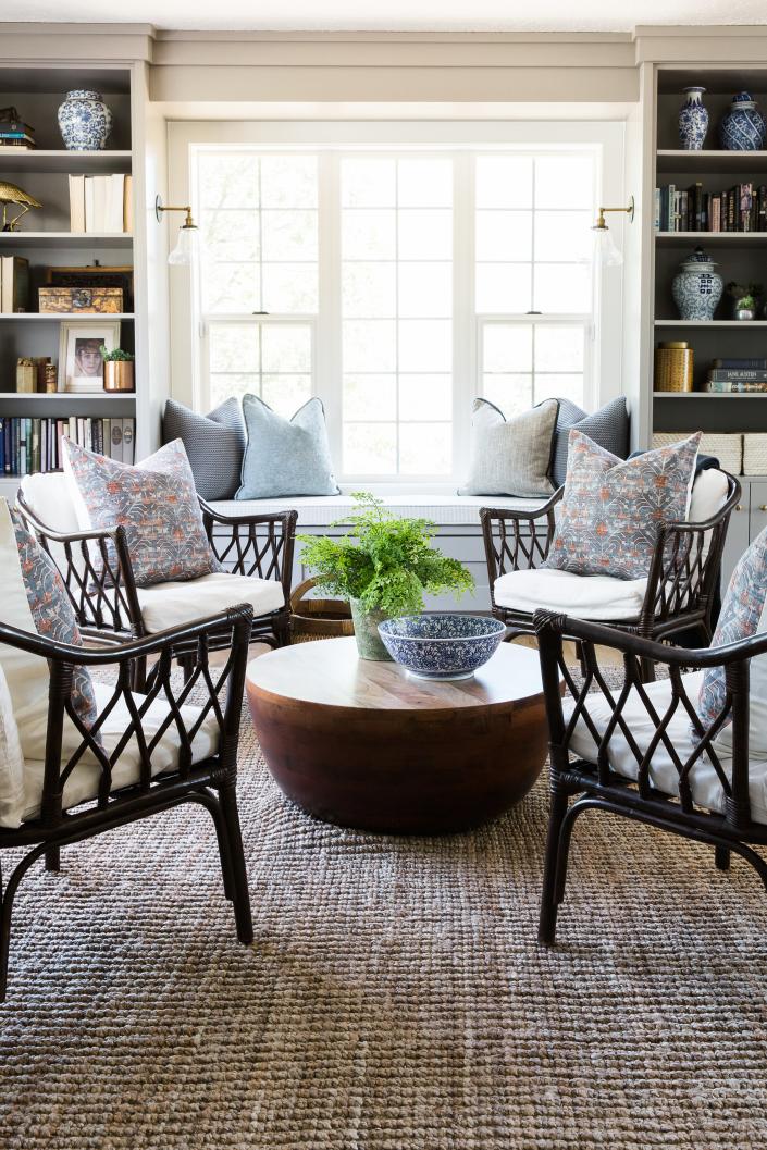 A modern farmhouse seating area makes use of a textured rug and open shelving.