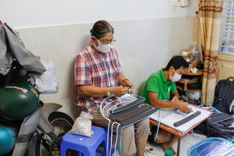 A woman makes plastic face masks during the outbreak of the coronavirus disease (COVID-19), in Ho Chi Minh, Vietnam