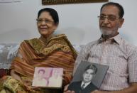 Nisar Akhtar, 76, and his wife Naushaba Siddiqui pose with pre-Partition photos during an interview with AFP in Karachi