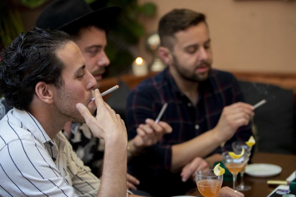 Three men smoking joints.