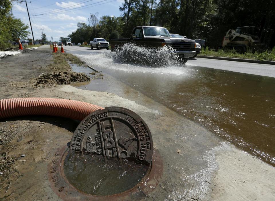 Water pours out of a manhole cover during high-tide flooding in Summerville, S.C. <a href="https://newsroom.ap.org/detail/EastCoastRainstormSouthCarolina/904e8b2bbe9743bfa7a18d9ab5560700/photo" rel="nofollow noopener" target="_blank" data-ylk="slk:AP Photo/Mic Smith;elm:context_link;itc:0;sec:content-canvas" class="link ">AP Photo/Mic Smith</a>