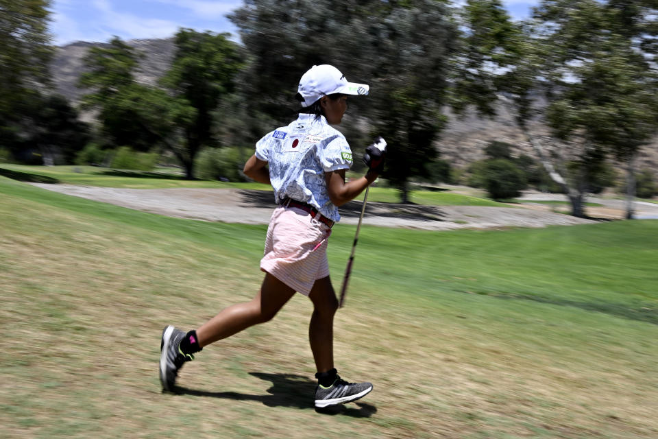 Miroku Suto of Japan runs to her cart on the fifth hole during the final round of the Junior World Championships golf tournament at Singing Hills Golf Resort on Thursday, July 14, 2022, in El Cajon, Calif. (AP Photo/Denis Poroy)