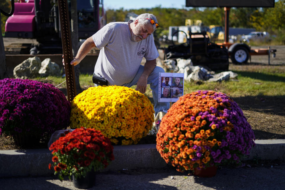 Richard Morlock, a member of the deaf community and surviver of the mass shooting at Schemengees Bar and Grille, pays his respect at a makeshift memorial to his friends he played cornhole with who were killed during the recent mass shooting in Lewiston, Maine, Saturday, Oct. 28, 2023. (AP Photo/Matt Rourke)