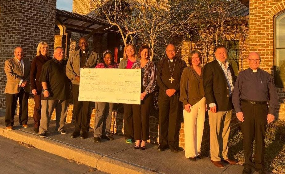 Representatives of the Bayou Community Foundation and Catholic Charities gather to mark the $500,000 donation.