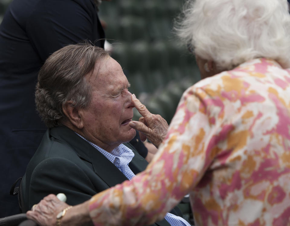 FILE - In this May 3, 2015, file photo, Barbara Bush applies sunscreen to the nose of her husband, former President George H.W. Bush, before the Seattle Mariners take on the Houston Astros in a baseball game in Houston, Texas. Both Bushes have been hospitalized this week in Houston, where the former president is being treated for pneumonia and his wife for bronchitis. (AP Photo/George Bridges, File)