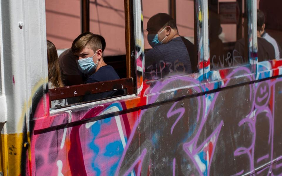 In Portugal, as seen on this Lisbon tram, people wear clean surgical masks whenever they enter an enclosed public space - Manu Fernandez/AP