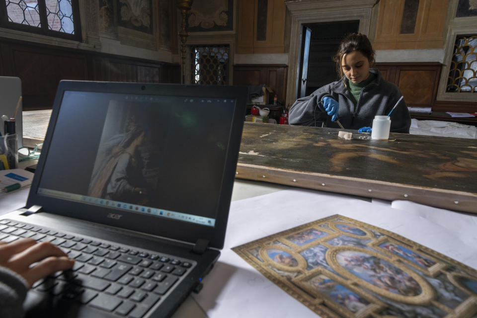 Las restauradoras Annalisa Tosatto y Alice Chiodelli trabajan en el estudio de conservación del Palacio Ducal de Venecia, el miércoles 7 de diciembre de 2022. (AP Foto/Domenico Stinellis)