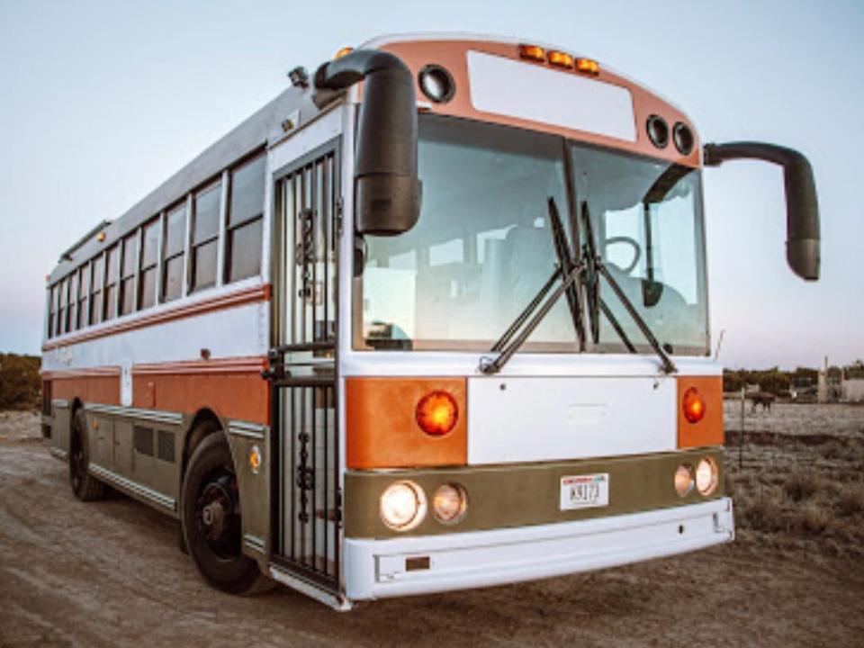 An outside view of the bus, which is painted orange and white