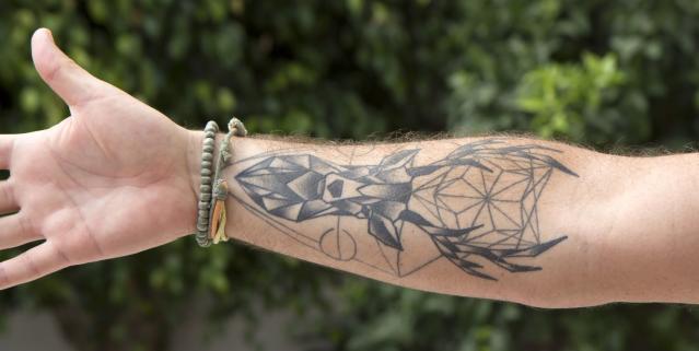 Gucci logo tattooed on inner forearm
