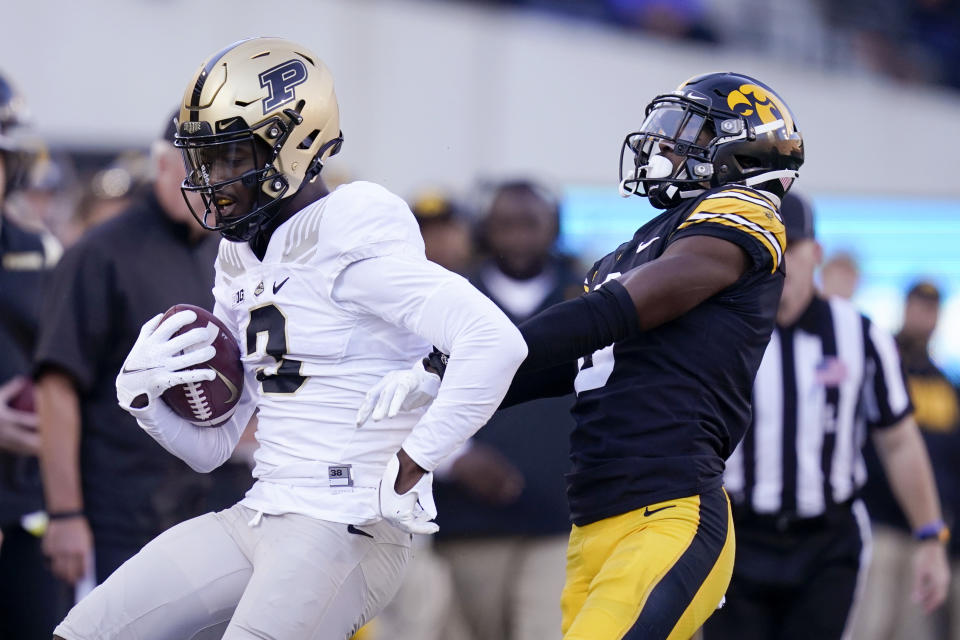 Purdue wide receiver David Bell (3) runs from Iowa defensive back Matt Hankins, right, after catching a pass during the second half of an NCAA college football game, Saturday, Oct. 16, 2021, in Iowa City, Iowa. Purdue won 24-7. (AP Photo/Charlie Neibergall)