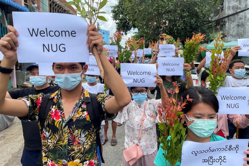 FILE PHOTO: Anti-government protesters hold placards to show their support and welcome the new National Unity Government found by ousted NLD legislators and call to continue strike from traditional new year in Myanmar, in Yangon