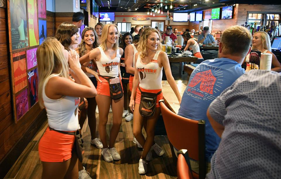 A group of Hooters Girls gather at the bar to perform a short song for a patron's birthday. The Hooters sports bar and restaurant opened in August 2018 in the old Logan's Roadhouse location on Call Field Road.