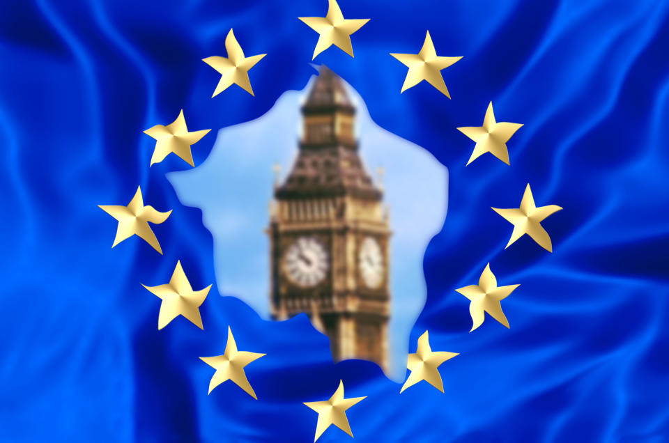 European flag broken by United Kingdom exit with blurred Big Ben tower of London, the house of a British parliament. The financial concept for Brexit and EU division.