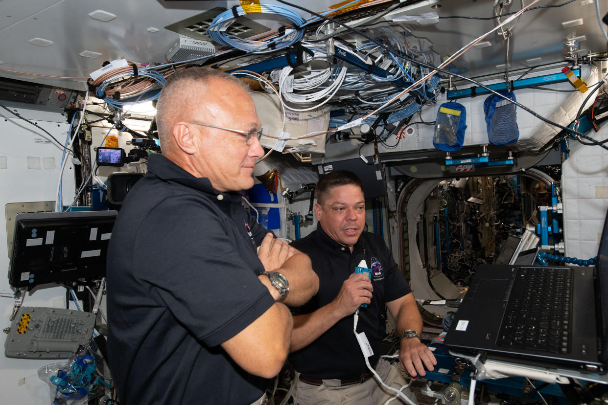  NASA astronauts Doug Hurley (foreground) and Bob Behnken brief mission controllers about their experience aboard SpaceX's Crew Dragon spacecraft, on June 1, 2020, shortly after arriving at the International Space Station aboard the private vehicle on SpaceX's Demo-2 test flight.  