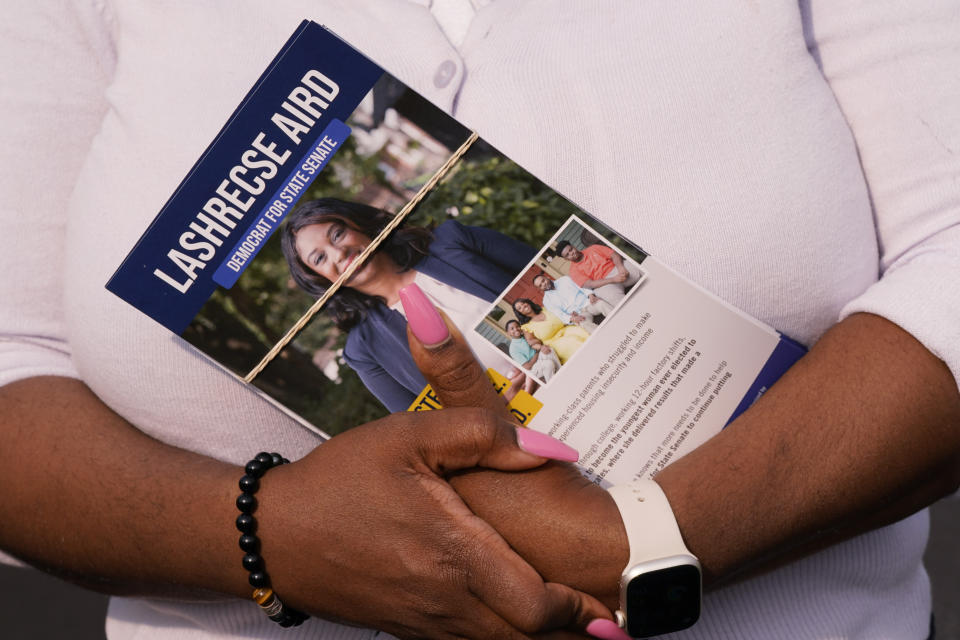 Former Delegate Lashrecse Aird holds door hangers as she canvases a neighborhood, Monday, May 22, 2023, in Henrico County, Va. Aird is challenging State Sen. Joe Morrissey in a Democratic primary for a newly redrawn senatorial district. (AP Photo/Steve Helber)