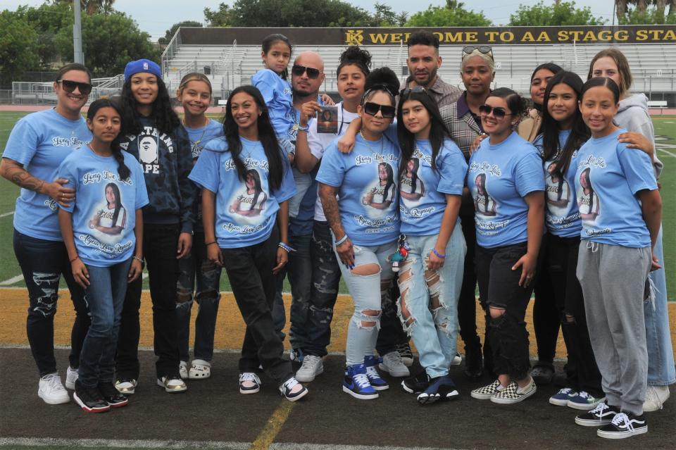 Members of Alycia Reynaga's family and Amos Alonzo Stagg High School girls softball team pose for a group photo with Tiffany Haddish and Jason Lee after the special assembly in Reynaga's memory. Reynaga, a 15-year-old Stagg freshman and softball player, was fatally stabbed on campus on April 18.