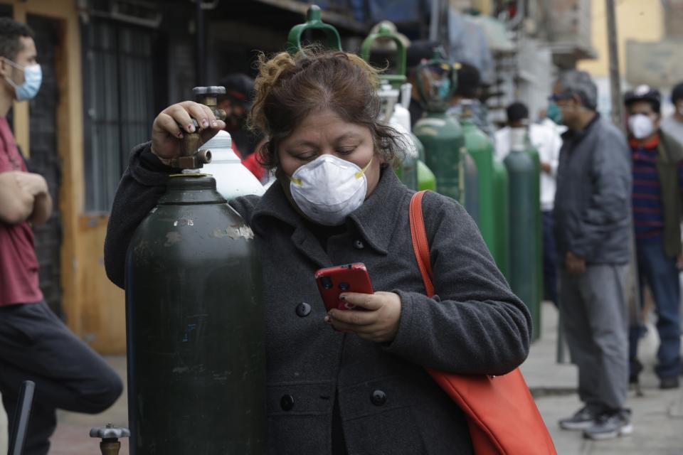 Una mujer hace cola para llenar un tanque de oxígeno en el Callao, Perú, el 3 de junio del 2020. (AP Photo/Martín Mejía)