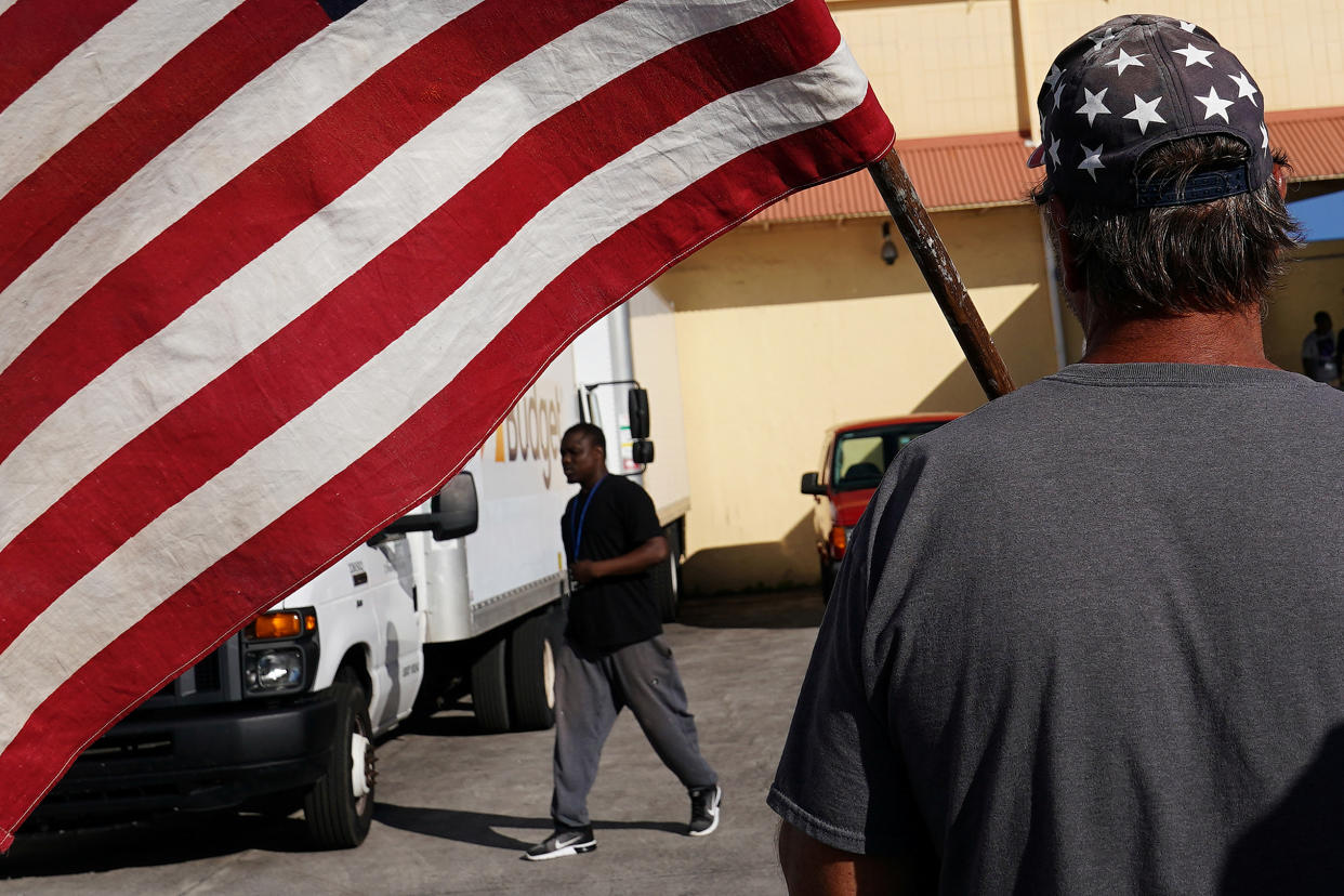 A man holding a flag verbally insults another man outside Broward County election offices during a ballot recount in Lauderhill, Fla. (Photo: Carlo Allegri/Reuters)