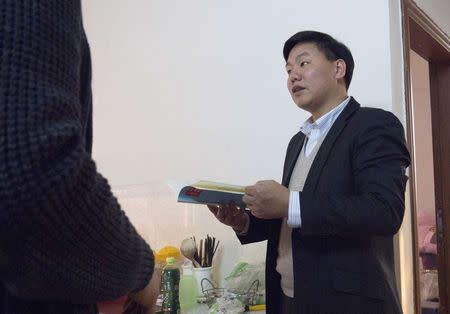 Zhang Zhiru, a prominent Shenzhen-based activist, holds a book before an interview in Guangzhou, Guangdong province, January 20, 2015. REUTERS/ Alexandra Harney