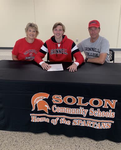 <p>Instagram/lisabluder </p> Lisa and David Bluder sit alongside their son David Jr. as he commits to college.