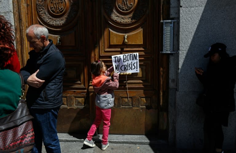 Placard reading "Your loot, my crisis" reflects public anger over political corruption