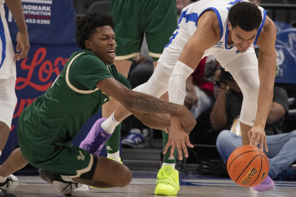 South Florida guard Brandon Stroud, left, and Memphis forward Nick Jourdain vie for the ball during the first half of an NCAA college basketball game Thursday, Jan. 18, 2024, in Memphis, Tenn. (AP Photo/Nikki Boertman)