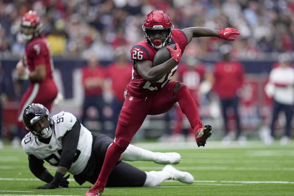 Houston Texans running back Devin Singletary (26) avoids a tackle attempt by Jacksonville Jaguars defensive end Angelo Blackson (90) in the second half of an NFL football game in Houston, Sunday, Nov. 26, 2023. (AP Photo/Eric Gay)