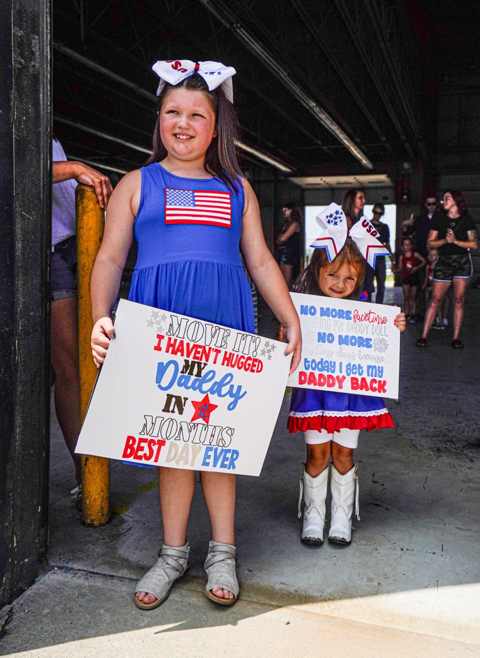 From left, Amelia and Melanie Brenchley wait for their father with the Indiana National Guard 163rd Field Artillery Regiment, headquartered in Evansville, to deplane after deployment in Iraq on Thursday, Aug.3, 2023, near the Indianapolis International Airport.