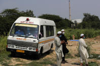 An ambulance leaves after delivering the body of a COVID-19 victim at a graveyard in New Delhi, India, Wednesday, Sept. 16, 2020. India is now second in the world with the number of reported coronavirus infections with over 5.1 million cases, behind only the United States. Its death toll of only 83,000 in a country of 1.3 billion people, however, is raising questions about the way it counts fatalities from COVID-19. (AP Photo/Manish Swarup)