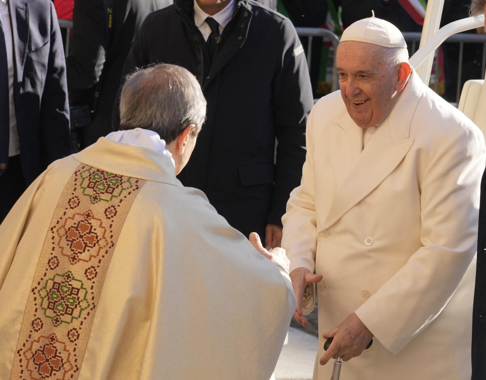 Pope Francis is welcomed by the bishop of Asti, Marco Prastaro, left, as he arrives to preside over the holy mass in the Cathedral of Asti, northern Italy, Sunday, Nov. 20, 2022, to meet the diocesan community from which his parents had left to emigrate to Argentina and the young people from all over the region on the occasion of the XXXVII World Youth Day. (AP Photo/Gregorio Borgia)