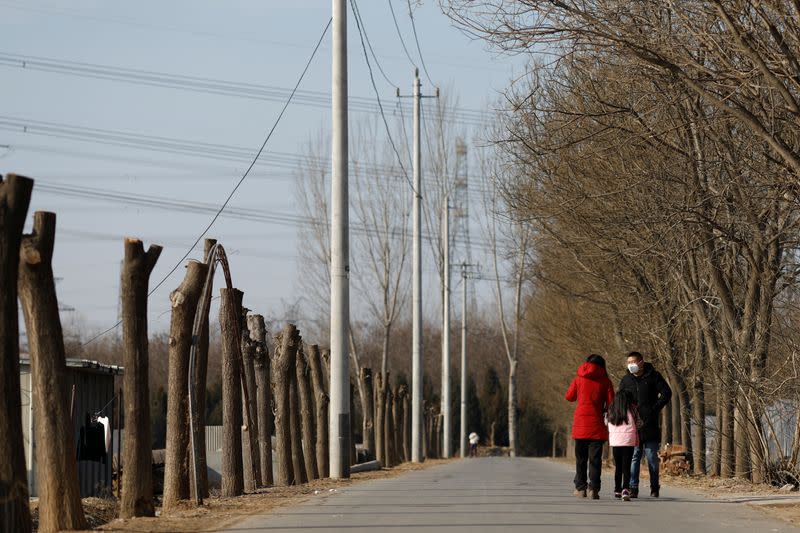 A man wearing a face mask walks along a street, as the country is hit by an outbreak of the new coronavirus, on the outskirts of Beijing