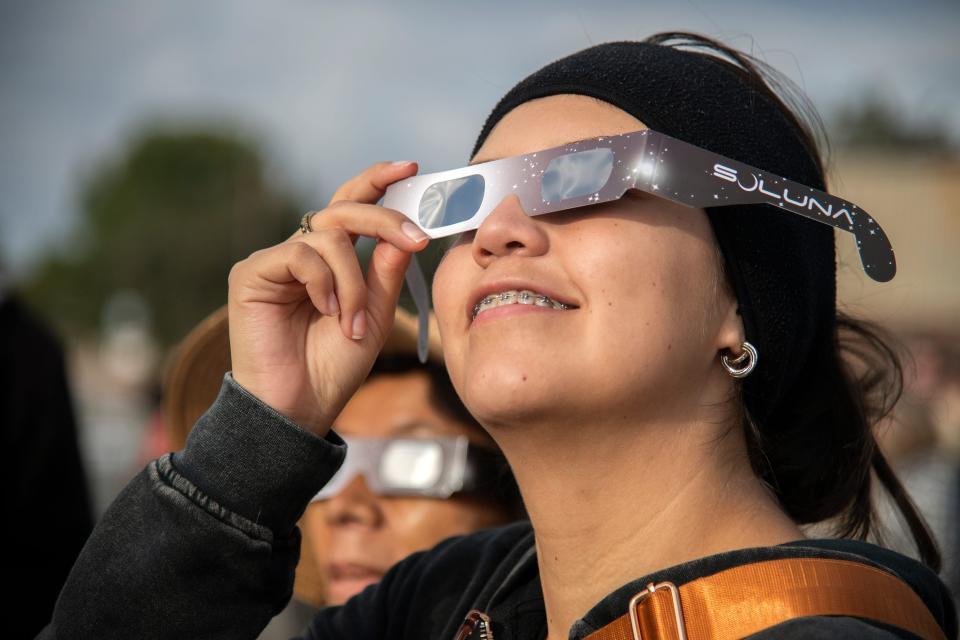 FILE - A spectator looks at the annular solar eclipse in October through special glasses during a watch party on the campus of San Joaquin Delta College in Stockton, CA. While Georgia will only see a partial eclipse, it's still not safe to look at the eclipse without using safety devices like these glasses.