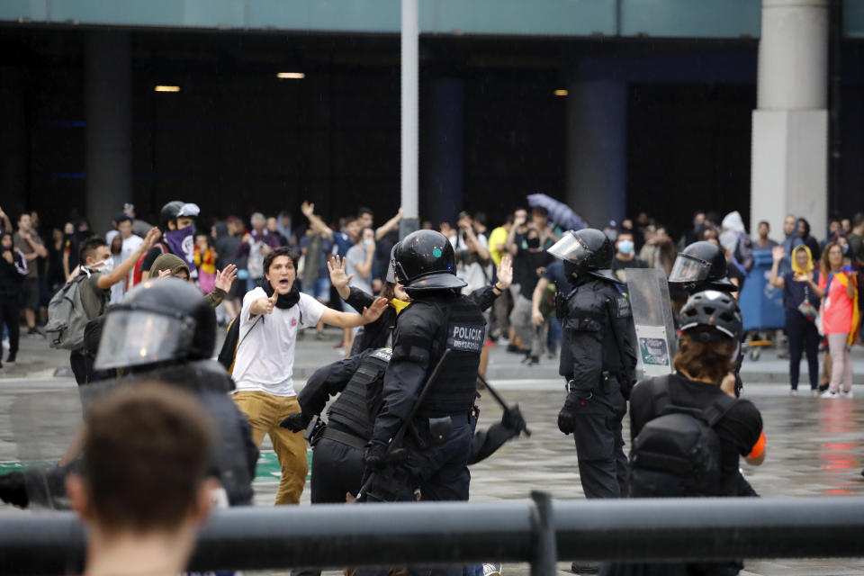 Policías antimotines se enfrentan con manifestantes afuera del aeropuerto El Prat, en Barcelona, el lunes 14 de octubre de 2019. (AP Foto/Emilio Morenatti)