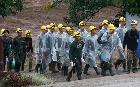 Rescuers walk toward the entrance to the cave on Tuesday morning - Credit: Sakchai Lalit /AP