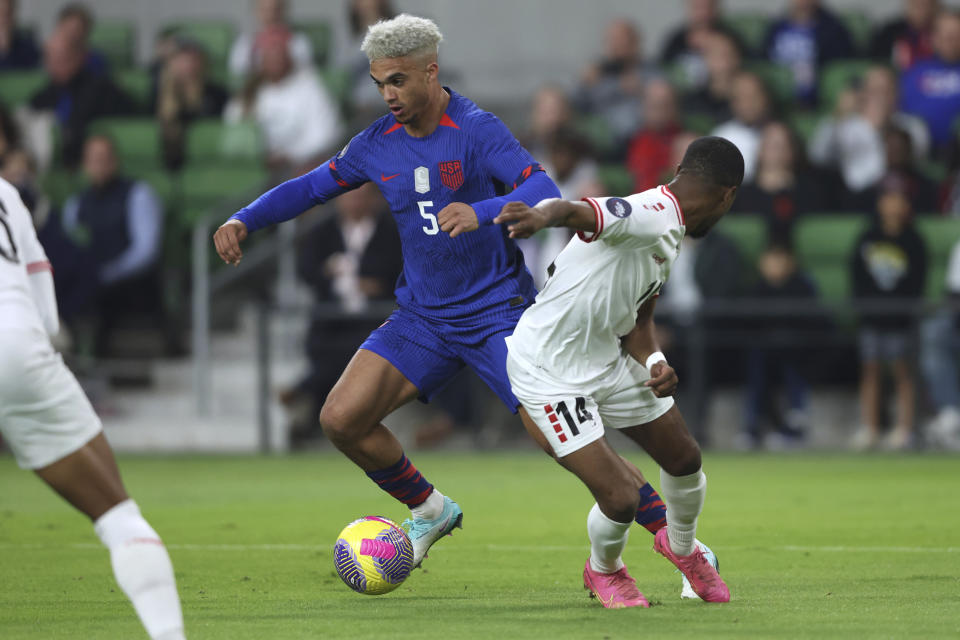 U.S. defender Antonee Robinson (5) dribbles past Trinidad and Tobago defender Shannon Gomez (14) during the first half of the first leg of a CONCACAF Nations League soccer quarterfinal Thursday, Nov. 16, 2023, in Austin, Texas. (AP Photo/Stephen Spillman)