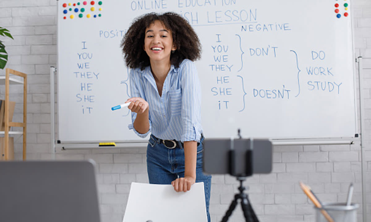 This is a photo of a teacher recording herself teaching on a phone.