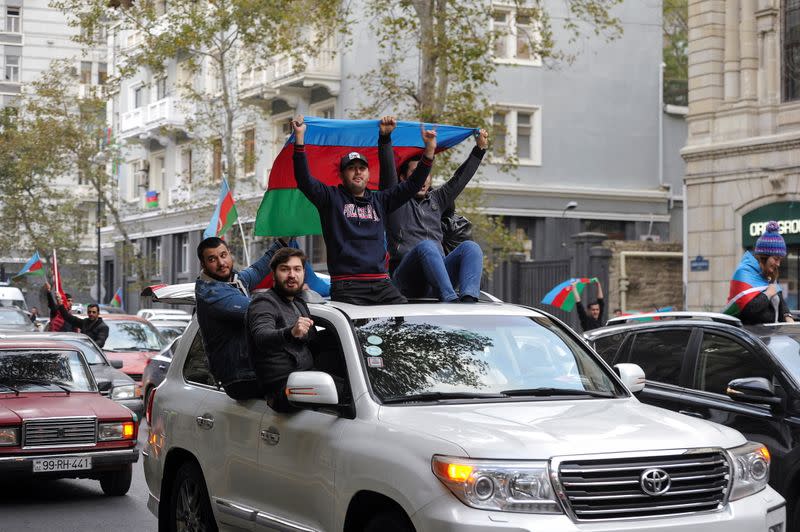 People take part in celebrations following the signing of a deal to end the military conflict over the Nagorno-Karabakh region in Baku