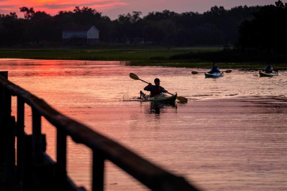 Kayakers return from a sunset paddle around BowenÕs Island on the Folly River.