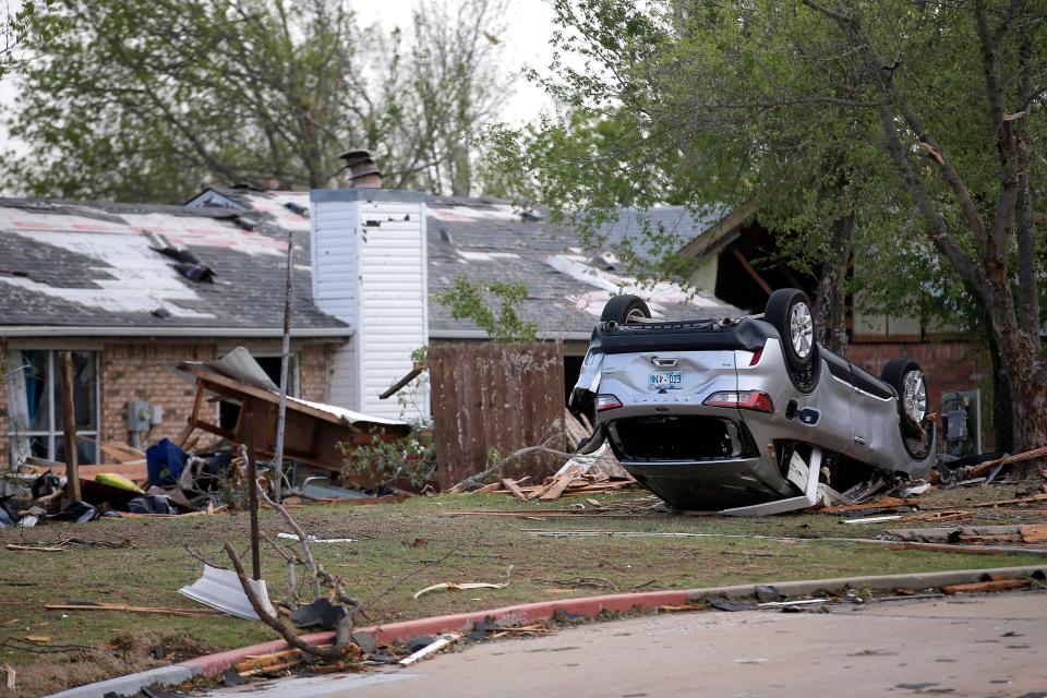 A car is pictured upside down at a home on Kickapoo St., Thursday, April, 20, 2023, in Shawnee, Okla., after tornado moved through the area Wednesday night in Shawnee, Okla.