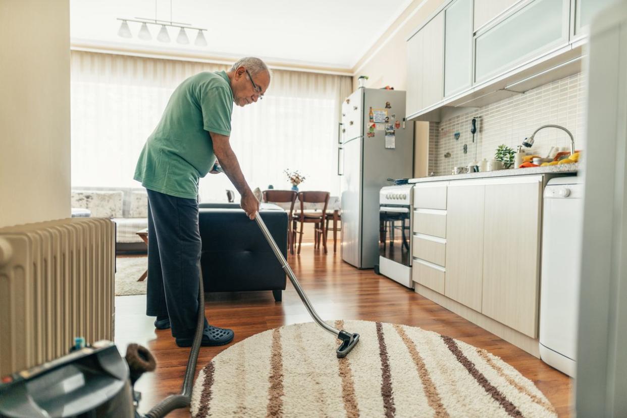 Senior Man Vacuum Cleaning Home