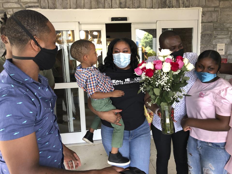 Teisha Roberts, center, a nursing director, is greeted by her family as she prepares to leave Park Springs elder care facility in Stone Mountain, Ga., Saturday, June 13, 2020. Workers who agreed to live at Park Springs to keep its residents safe from the coronavirus are back with their loved ones for the first time in nearly three months. (AP Photo/Sudhin S. Thanawala)