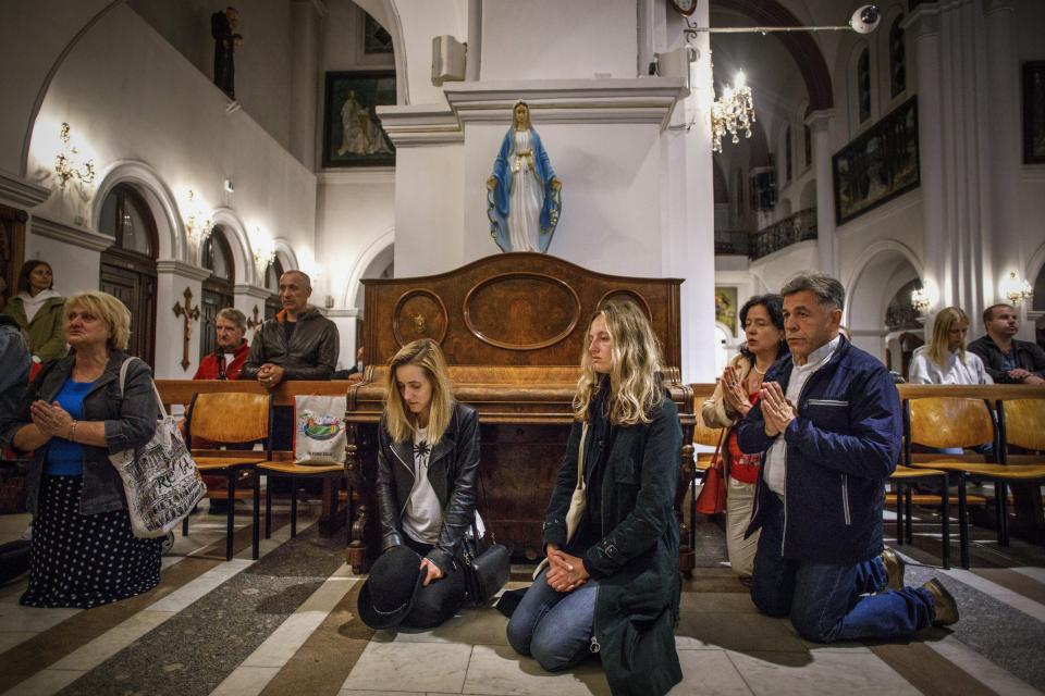 FILE - People pray inside the Sts. Simon and Helena Catholic Church in Minsk, Belarus, Wednesday, Aug. 26, 2020. Amid anti-government demonstrations, protesters took refuge from riot police inside the landmark known as the “Red Church” for the color of its bricks. Authorities later halted services at the church. (AP Photo, File)