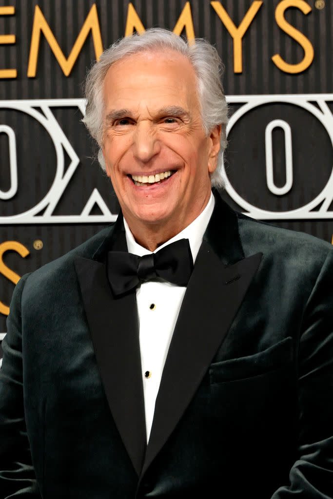 Henry in a dark velvet tuxedo with bow tie, smiling at camera