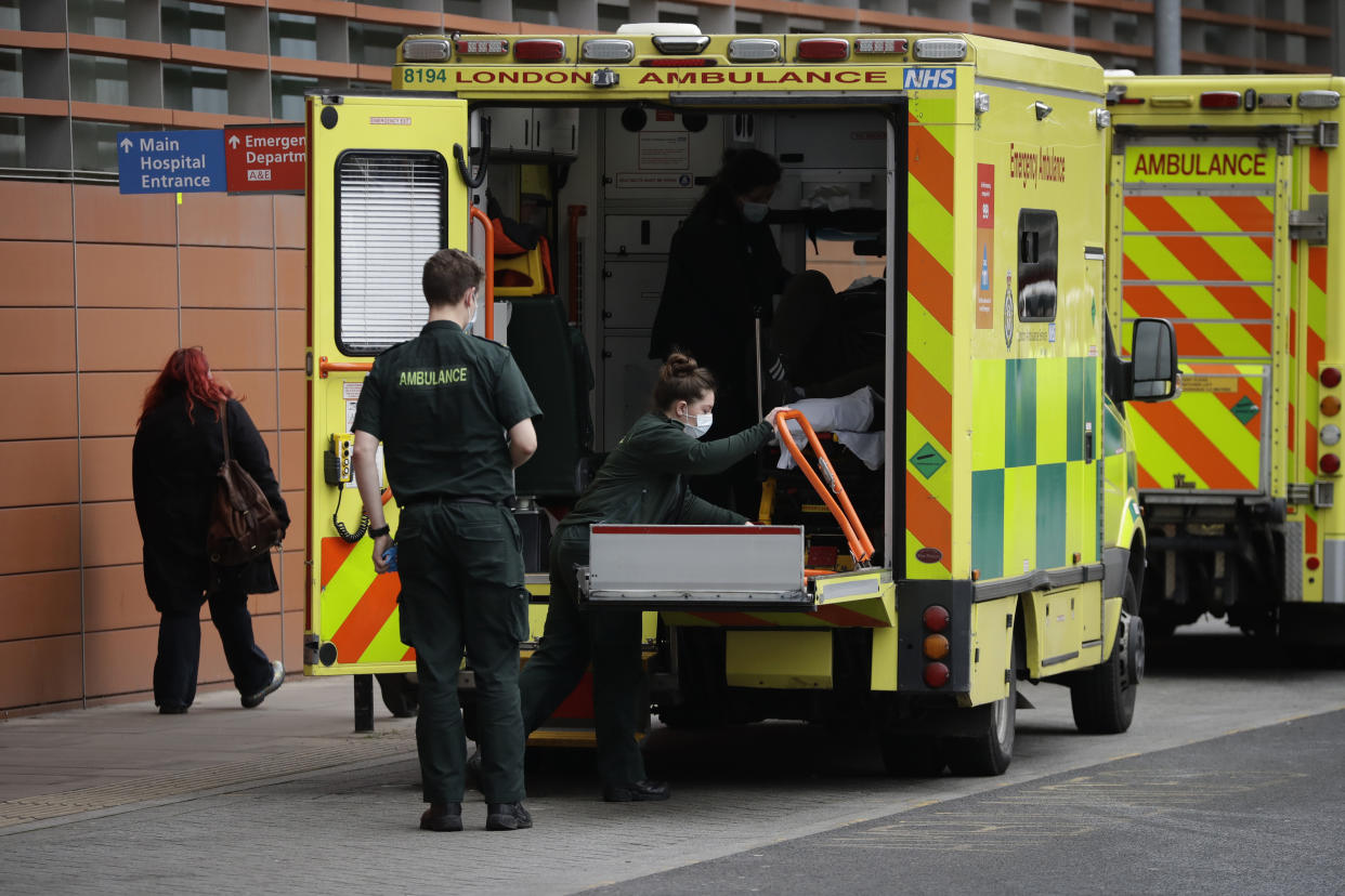 Medics prepare to take a patient out from the back of an ambulance after arriving outside the Royal London Hospital in east London, Thursday, Feb. 4, 2021, during England's third national lockdown since the coronavirus outbreak began. The U.K. is under an indefinite national lockdown to curb the spread of the new variant, with nonessential shops, gyms and hairdressers closed, most people working from home and schools largely offering remote learning. (AP Photo/Matt Dunham)