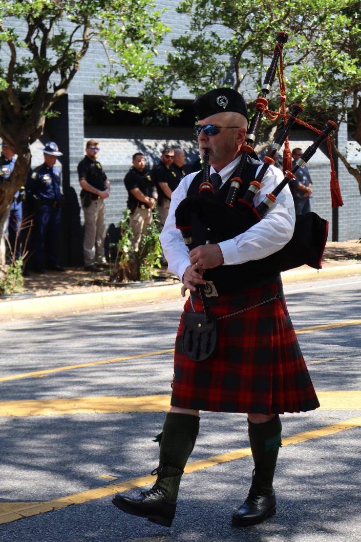 Bagpiper Neil Johnston walks down Murray Street while playing at the end of the 24th annual Law Enforcement Memorial in downtown Alexandria on Friday.