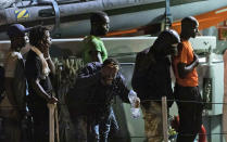 A migrants splashes water on his face as he disembarks with others from an Italian Guardia di Finanza finance police boat at the Sicilian port of Pozzallo, southern Italy, early Tuesday, July 9, 2019. According to reports 53 migrants were rescued in the Sicilian Channel by an Italian Coast Guard patrol vessel, but six of them were immediately transferred to Lampedusa due to medical conditions. (Ciccio Ruta/ANSA via AP)