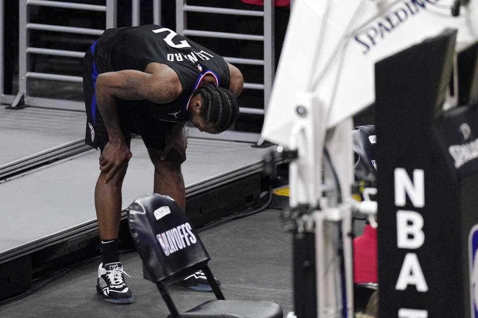 Los Angeles Clippers forward Kawhi Leonard holds his knee after stepping awkwardly during the second half in Game 4 of a second-round NBA basketball playoff series against the Utah Jazz Monday, June 14, 2021, in Los Angeles. (AP Photo/Mark J. Terrill)