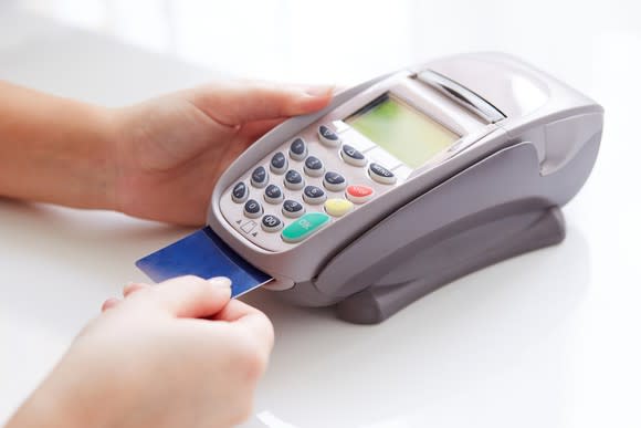 A credit card being processed at a check out counter.